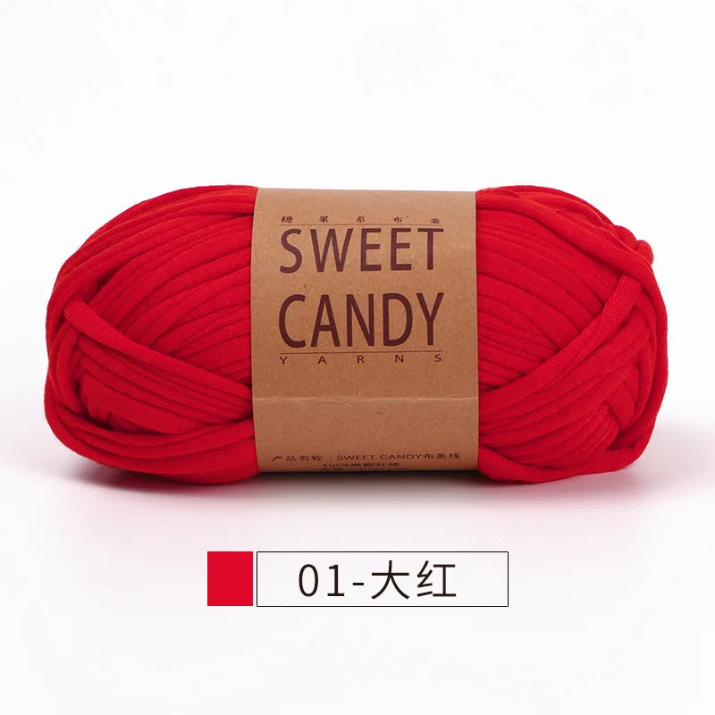 A ball of bright red sweet candy yarn with a brown label and a red and white identification tag.