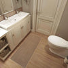 A rectangular beige non-slip faux sisal kitchen rug placed on a light wood floor.
