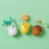 Three ceramic landscape fridge magnets featuring white, yellow, and terracotta tones with dried floral accents.