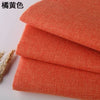 A stack of orange coarse linen and cotton fabric rolls.