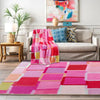 A pink and red retro checkerboard geometric rug laid out on a wooden floor.