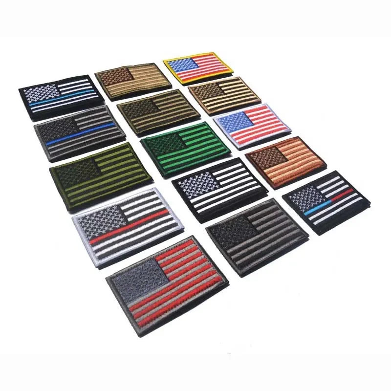 A collection of various USA flag patches with hook and loop backing in different designs and colors.