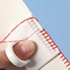 A hand is using a precision sewing guide template kit to mark a line on fabric with a needle and red thread.