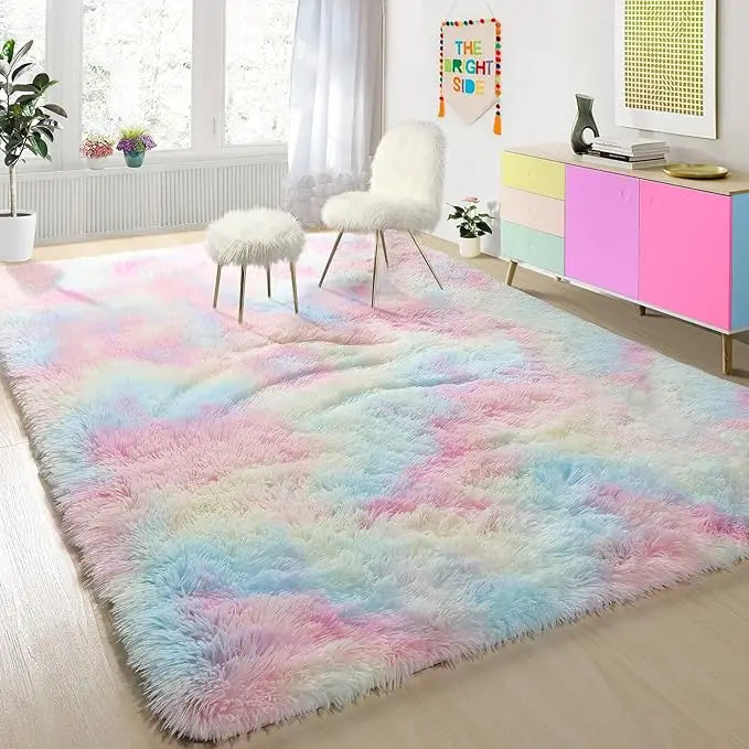 A fluffy tie-dyed pink and blue plush floor mat in a room with a window and a white chair.