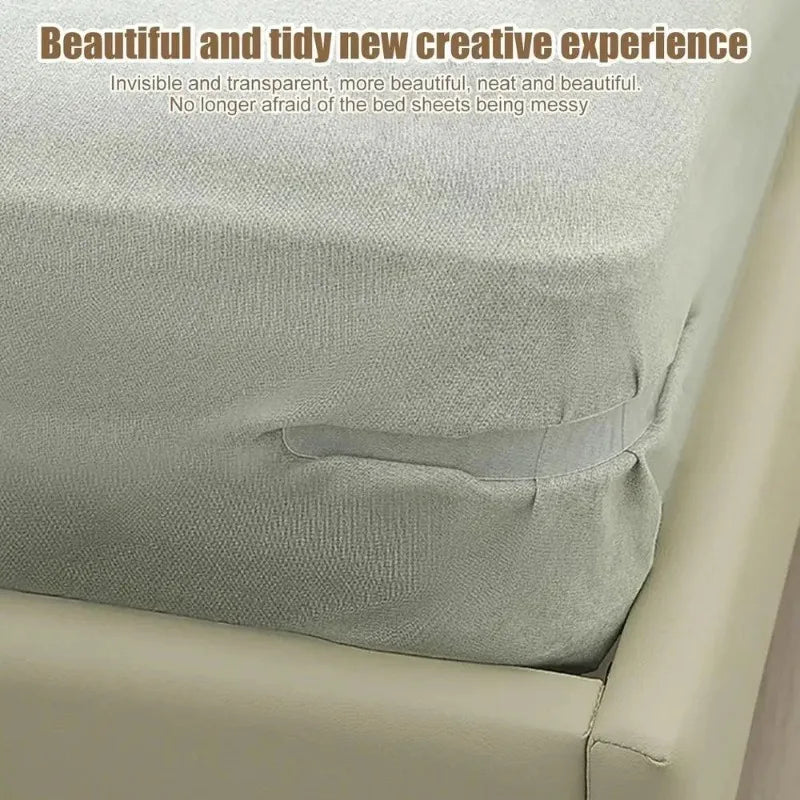 A close-up of a light gray bed sheet corner tightener clip being used to keep sheets neat on a bed.