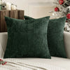 A dark green chenille pillow cover with a textured weave resting on a white surface.