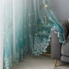 Light teal sheer curtains with delicate floral wave lace trim draped in a modern interior.