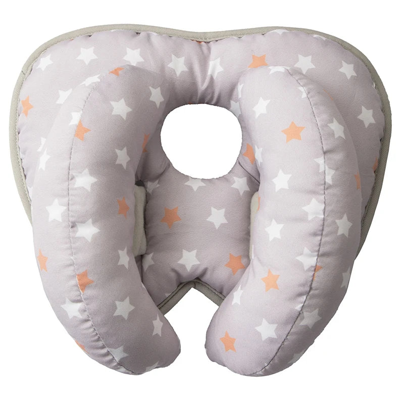 A light gray baby head and neck support pillow with star patterns for strollers and car seats.