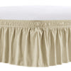 A beige elastic bed skirt with ruffled trim and gathered fabric.