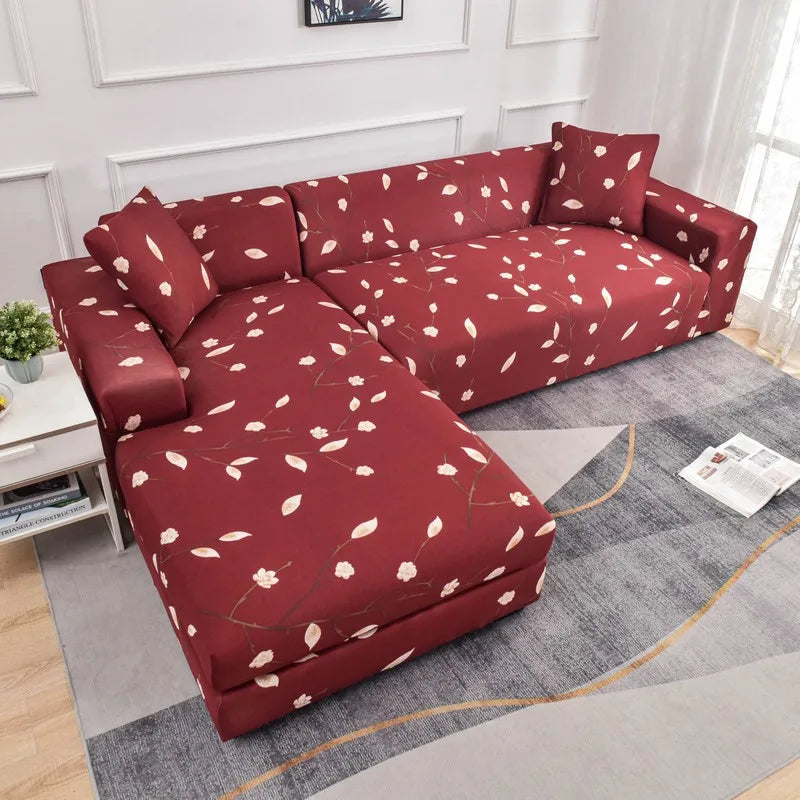 A deep red L-shaped sofa protector cover with a white floral pattern displayed indoors.