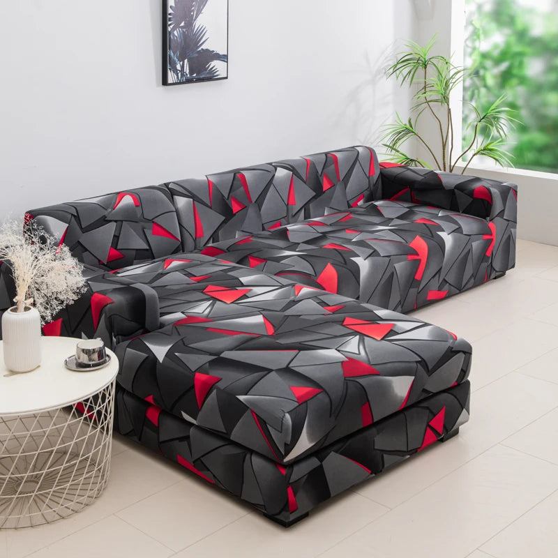 A black and red geometric patterned sofa protector cover lying on a light floor.