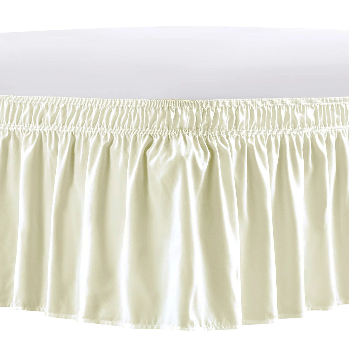 A cream-colored elastic bed skirt featuring delicate ruffles and a gathered hemline.