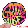 A round black embroidered patch with colorful text that reads GOOD VIBES