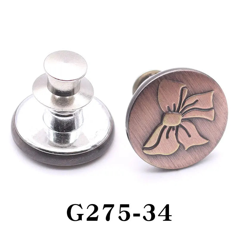 A round, rose gold-toned button pin featuring a delicate bow design.
