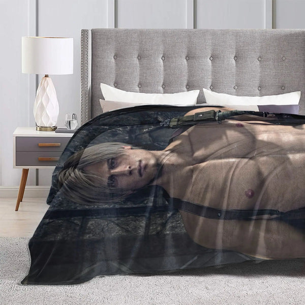 A person lying down under a dark graphic throw blanket in a bedroom setting.