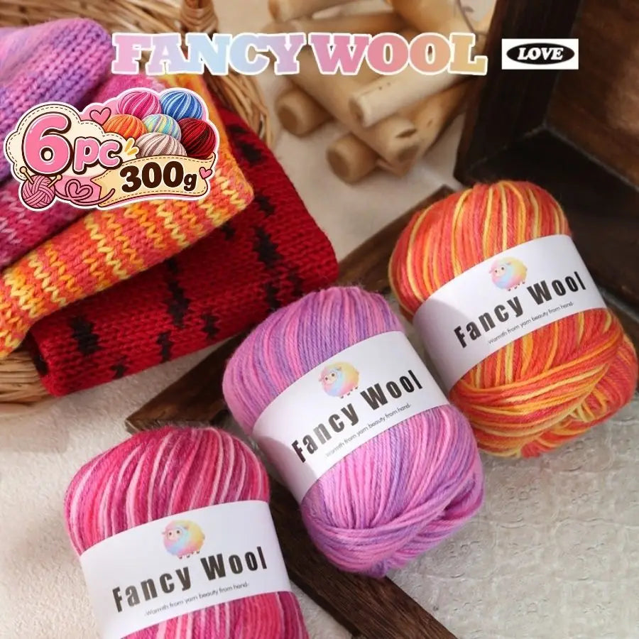 A collection of pink, orange, and yellow gradient wool yarn skeins displayed on a wooden surface.