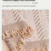 Close-up of a beige textile fabric showing a woven texture and a fringed edge.