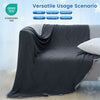 A dark gray quilted blanket draped over a sofa, shown in a versatile usage scenario.