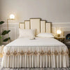White embroidered cotton bedspreads and pillowcases displayed on a bed with modern lighting.