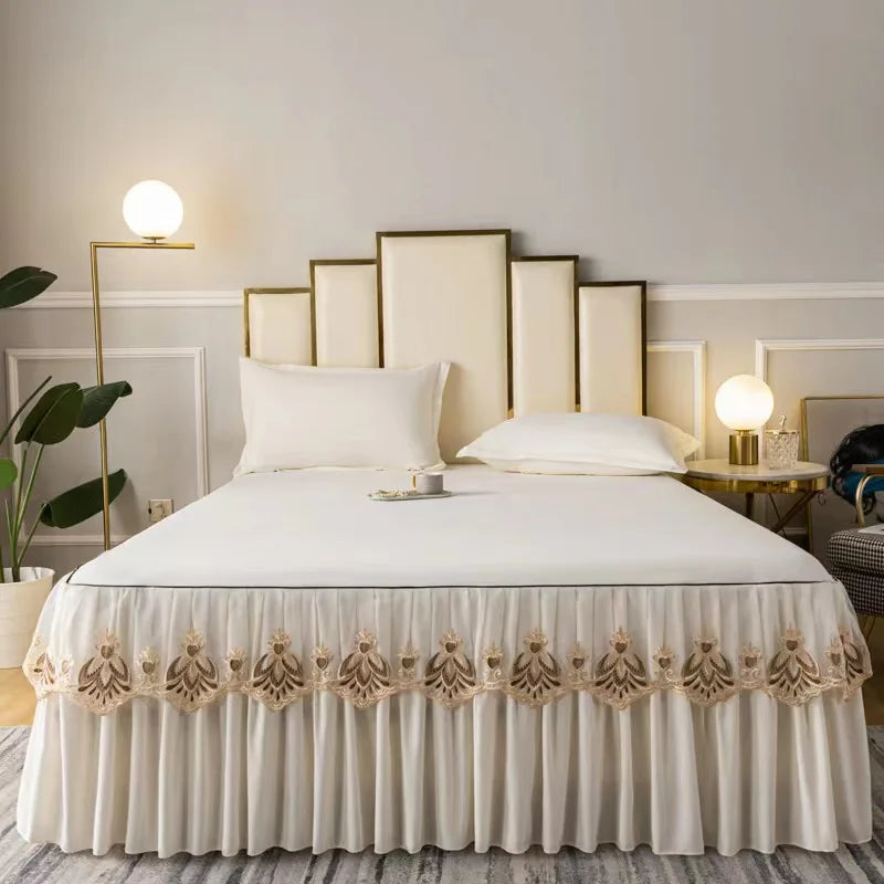 White embroidered cotton bedspreads and pillowcases displayed on a bed with modern lighting.