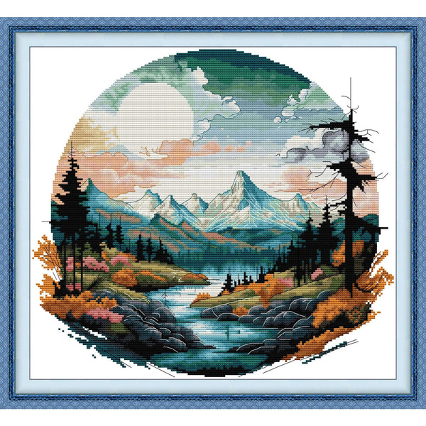 Cross stitch kit featuring an autumn mountain landscape with evergreen trees and a large sun.