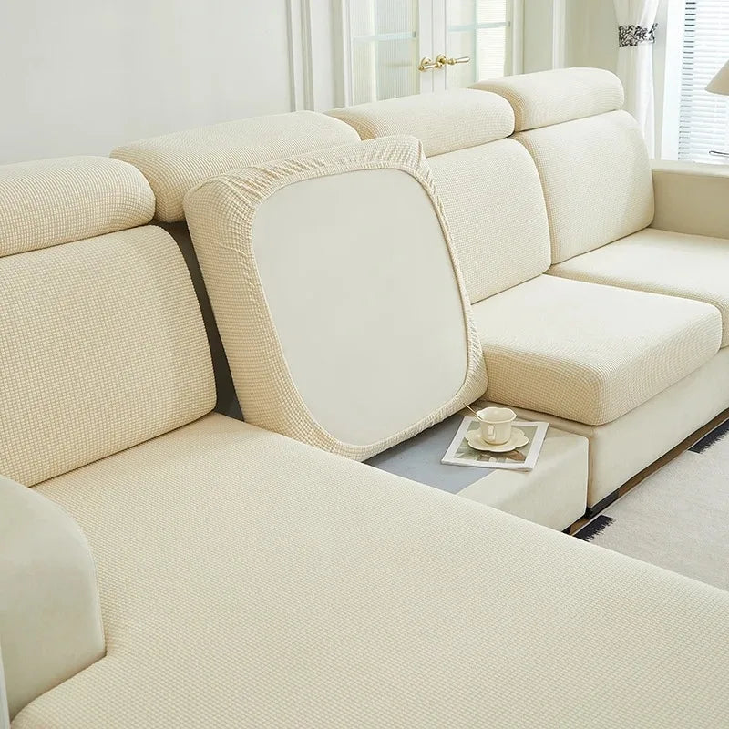 A light beige jacquard elastic sofa cushion slipcover on a modern sectional sofa.
