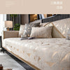 A luxurious beige and gold patterned sofa cover displayed on a bed, featuring geometric designs.