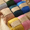 A collection of various colored premium 100% cotton yarn skeins in shades of green, blue, pink, and yellow.
