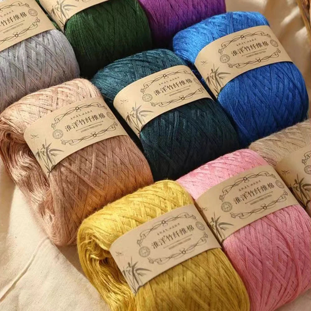 A collection of various colored premium 100% cotton yarn skeins in shades of green, blue, pink, and yellow.