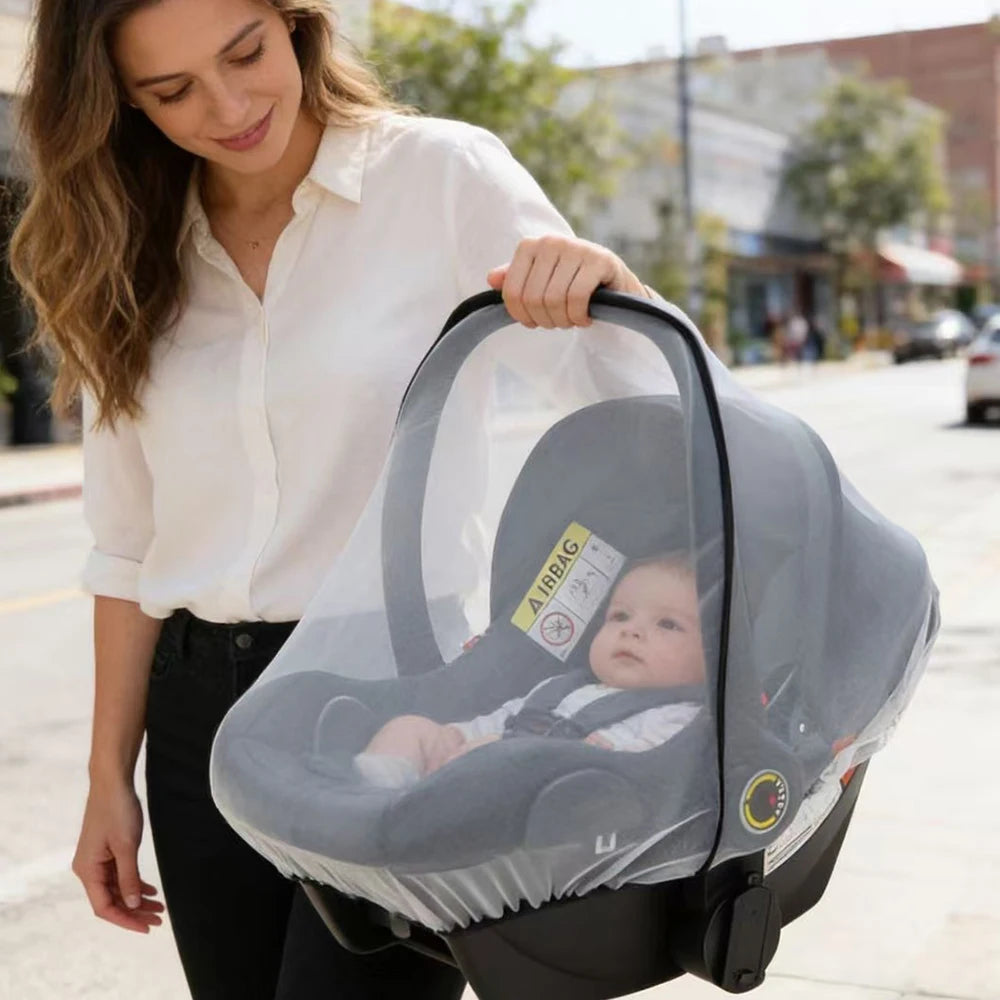 A woman holds a gray universal mosquito net for baby strollers and car seats.
