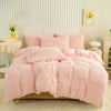 A fluffy pink plush duvet cover set displayed on a bed against a white paneled wall.