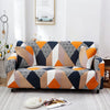 A modern sofa covered in a geometric pattern featuring shades of gray, black, orange, and beige.
