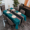 A long rectangular teal tablecloth set for dining or party decor with gold and red patterned accents.