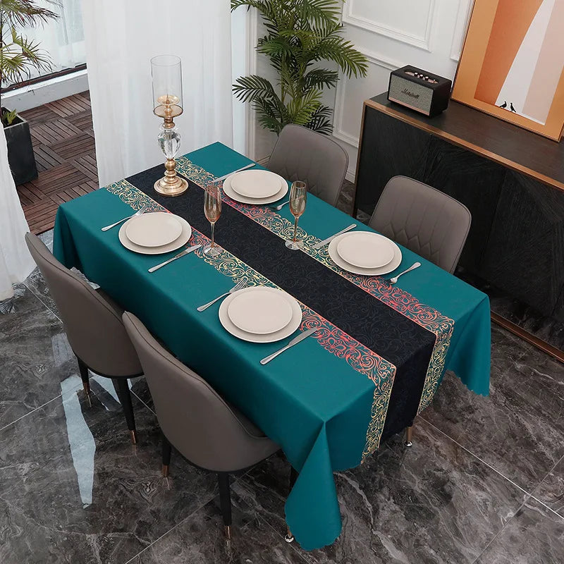 A long rectangular teal tablecloth set for dining or party decor with gold and red patterned accents.