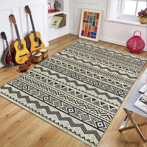A rectangular outdoor and indoor plastic straw rug with a geometric black and beige pattern on a wooden floor.