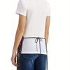 A white t-shirt worn by a person, featuring a black floral tatting apron tied around the waist.