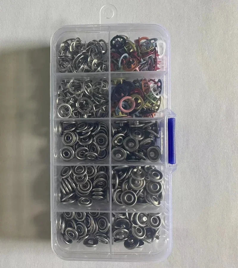 A clear plastic container holds various silver and colored five claw buckle clamps for fabric and accessories.