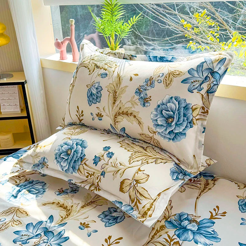 A fitted bed sheet with a floral print featuring blue and gold flowers on a white background.