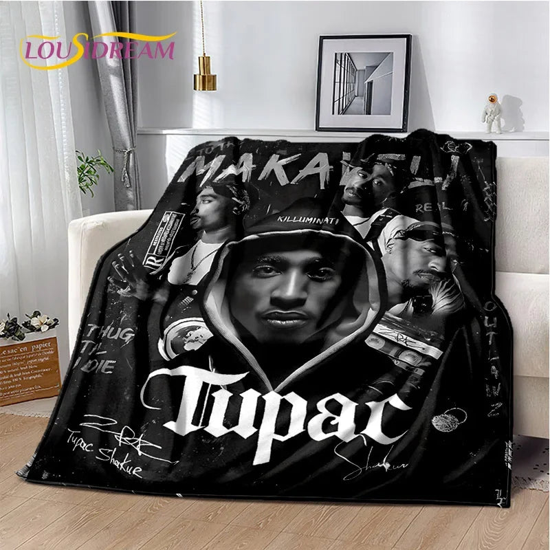 A black graphic throw blanket featuring a portrait of Tupac Shakur.