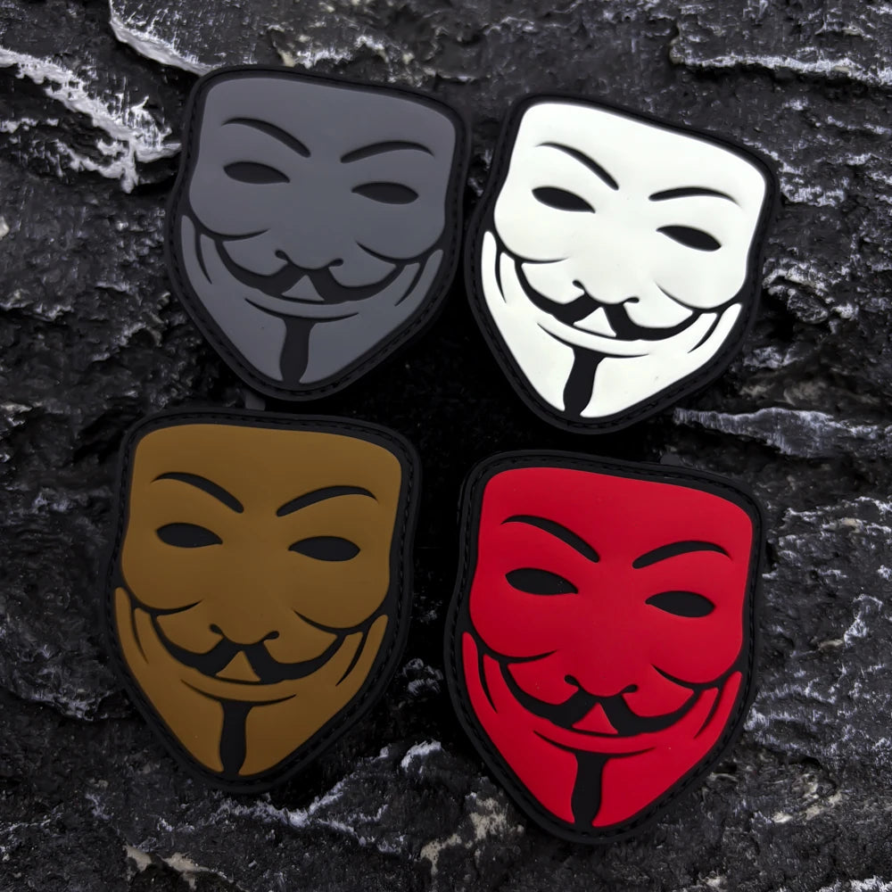 Four embroidered patches featuring different smiley face designs in black, white, and red on a dark textured background