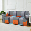 A modern sofa and chair slipcover featuring a patchwork design in gray, orange, blue, and black checkered patterns.