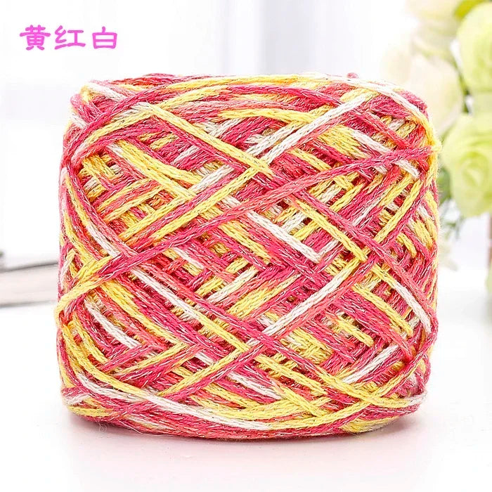 A ball of pink and yellow metallic silk yarn used for crocheting and knitting