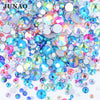 A pile of clear glass rhinestones in various colors including blue, pink, and green for DIY crafts