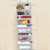 A gray hanging storage organizer with five shelves holding various stuffed animals and small items.