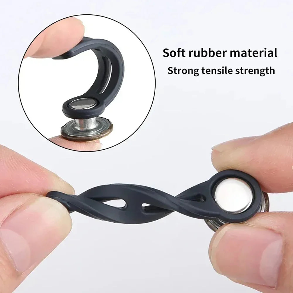 A hand holds a black universal waist extender button for jeans and pants, demonstrating its design.