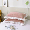 A set of two soft plaid washed cotton pillowcases with ruffled edges displayed on a white surface.