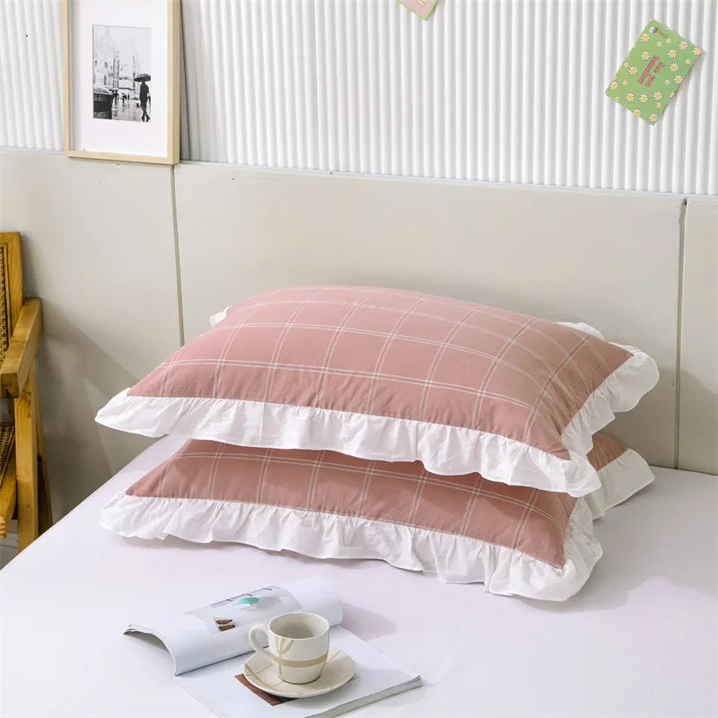 A set of two soft plaid washed cotton pillowcases with ruffled edges displayed on a white surface.