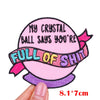 Pink embroidered patch shaped like a ball with purple ribbon and text saying My Crystal Ball says you're full of shit