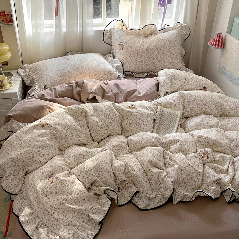 A floral bedding set featuring light beige and cream patterned pillows and a quilted comforter.