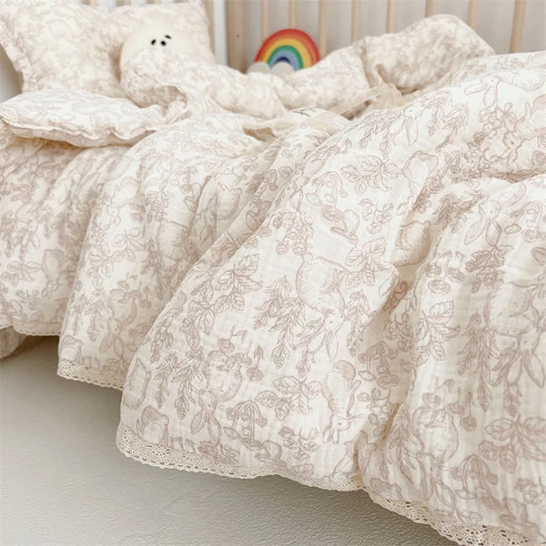 A soft, cream-colored muslin blanket with a delicate floral print is folded on a light surface.